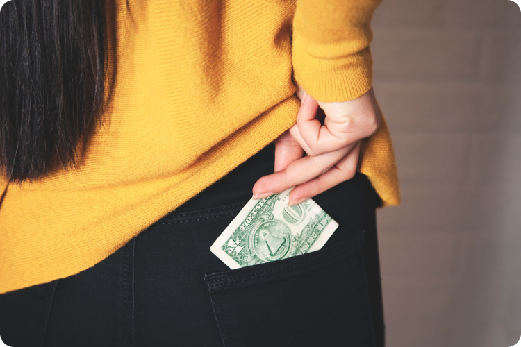 Image of a person putting money in her pocket